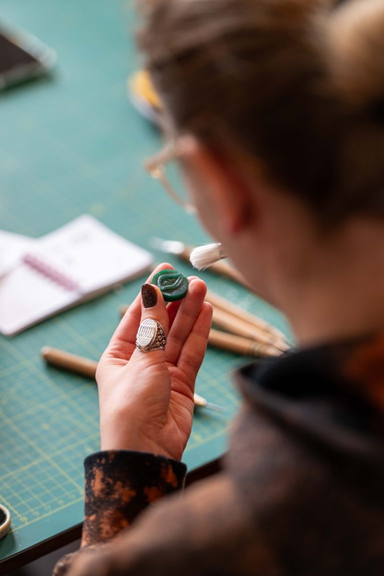 Person examining a green carved object